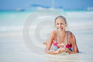 Girl in bikini lying and having fun on tropical beach photo