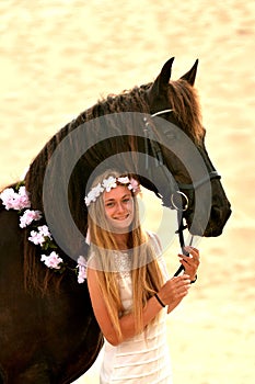 Beautiful girl with black Frisian horse