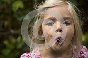 Beautiful Girl with Blackberry in the Garden.