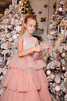 Beautiful girl with blond hair in elegant dress  posing in decorated room with Christmas details