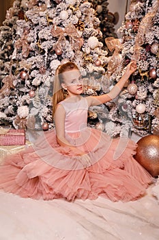 Beautiful girl with blond hair in elegant dress  posing in decorated room with Christmas details