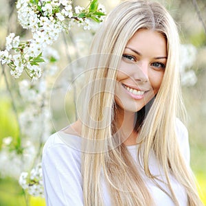 Beautiful girl in a blooming garden in spring - cloe up portrait