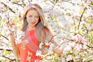 Beautiful girl in blooming tree in spring