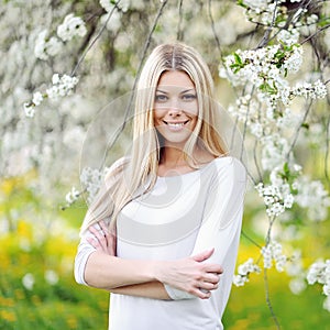 Beautiful girl in blooming tree in spring