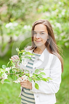 Beautiful girl blowing. portrait of a girl in a blooming apple tree.