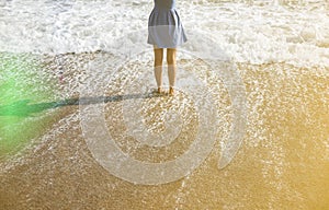 Beautiful girl in blue dress is walking on the beach. Amazing summer photo. Woman near the sea. Holiday travel concept. Slim legs