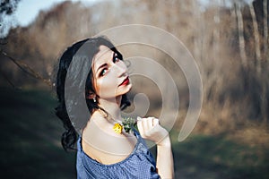 Beautiful girl in blue dress and yellow flower