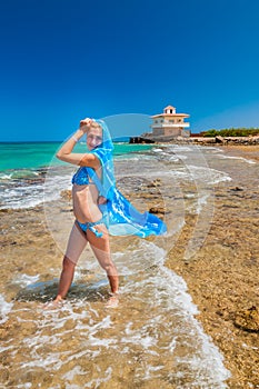 Beautiful girl with blue scarf on the beach