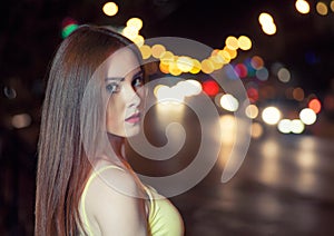 Beautiful girl on blurred carlights background with copyspace