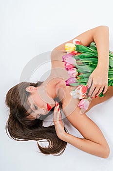 Beautiful girl with a bouquet of tulips isolated on white background