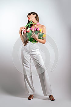 Beautiful girl with a bouquet of tulips isolated on white background