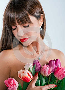 Beautiful girl with a bouquet of tulips isolated on white background