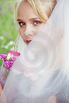 Beautiful girl bride blonde in gothic style with a bouquet in hand in summer