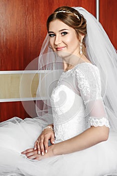 Beautiful girl, bride in a white dress on the background of the apartment. Wedding, bride`s gathering, family creation