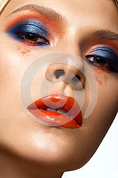 Beautiful girl with bright colored makeup and orange lips. Beauty face.