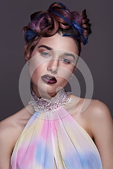 Beautiful girl with bright creative fashion makeup and colorful hairstyle. Studio portrait of beauty face.