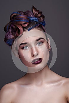 Beautiful girl with bright creative fashion makeup and colorful hairstyle. Studio portrait of beauty face.