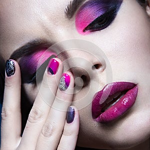 Beautiful girl with bright creative fashion makeup and colorful nail polish. Art beauty design.