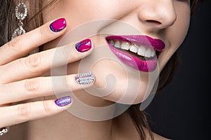 Beautiful girl with a bright evening make-up and pink manicure with rhinestones. Nail design. Beauty face.