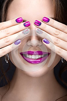 Beautiful girl with a bright evening make-up and purple manicure with rhinestones. Nail design. Beauty face.