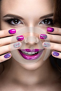 Beautiful girl with a bright evening make-up and purple manicure with rhinestones. Nail design. Beauty face.