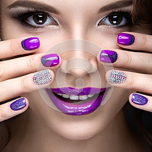 Beautiful girl with a bright evening make-up and purple manicure with rhinestones. Nail design. Beauty face.