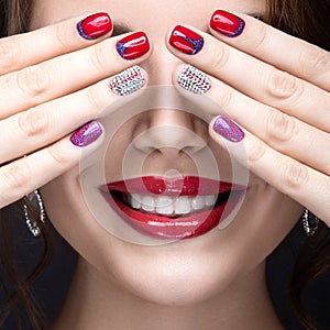 Beautiful girl with a bright evening make-up and red manicure with rhinestones. Nail design. Beauty face.