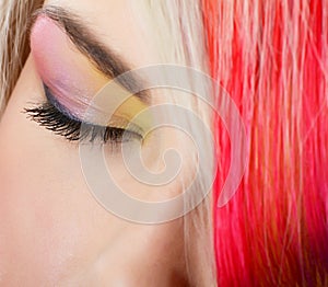 The beautiful girl with a bright make-up and multi-coloured strand in hair