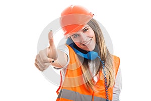 Beautiful girl builder rising thumb up