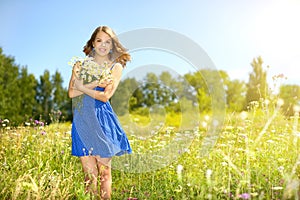 Beautiful girl with bunch of camomiles