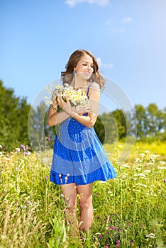 Beautiful girl with bunch of camomiles