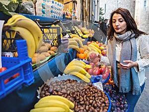 Beautiful girl buys fresh fruit at the supermarket