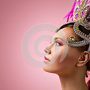 Beautiful Girl in carnival headdress on pink background.