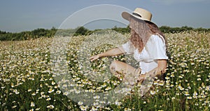 Beautiful girl in the chamomile field