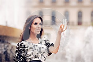 Beautiful Girl with Champagne Glass Celebrating by the Fountain