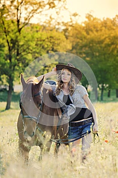 Beautiful girl with chestnut horse in evening field