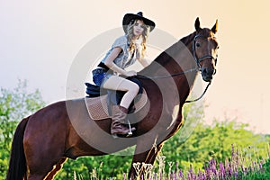 Beautiful girl with chestnut horse in evening field