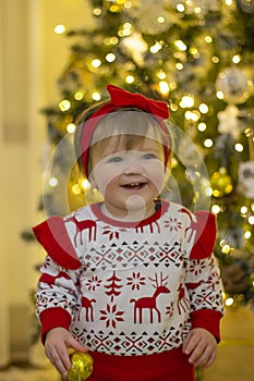 Beautiful girl in Christmas costume on background of Christmas tree. Cute smiling girl for New Year