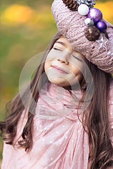 Beautiful girl with a Christmas wreath in pink as a hat