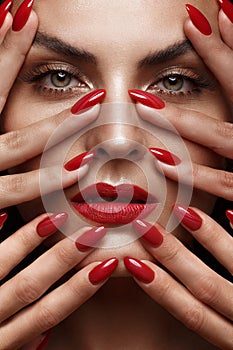 Beautiful girl with a classic make-up and red nails. Manicure design. Beauty face.