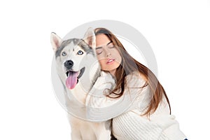 beautiful girl with closed eyes hugging husky dog