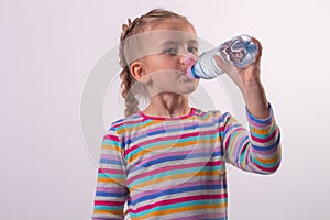 a beautiful girl in a colored jacket drinks water