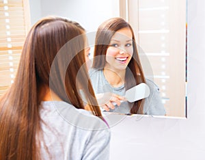 Beautiful girl is combing her long silky hair