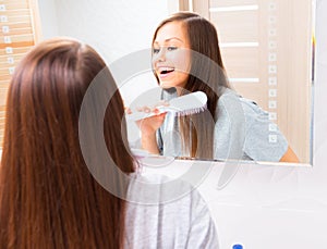 Beautiful girl is combing her long silky hair