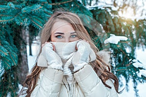 A beautiful girl covers her face with a white scarf, close-up of the look and eye. Casual make-up white mittens