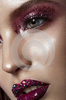 Beautiful girl with creative bright makeup with rhinestones . Beauty face. photo