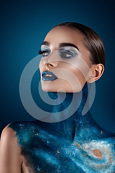 Beautiful girl with creative make-up . Bright colors blue lips. Conceptual art the cosmos, the universe