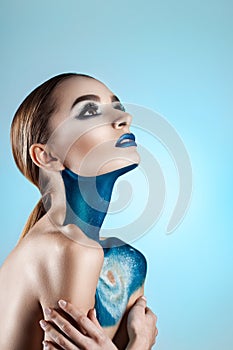 Beautiful girl with creative make-up . Bright colors blue lips. Conceptual art the cosmos, the universe