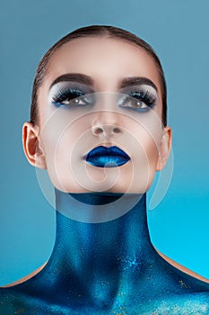 Beautiful girl with creative make-up . Bright colors blue lips. Conceptual art the cosmos, the universe