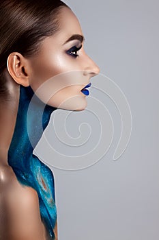 Beautiful girl with creative make-up . Bright colors blue lips. Conceptual art the cosmos, the universe